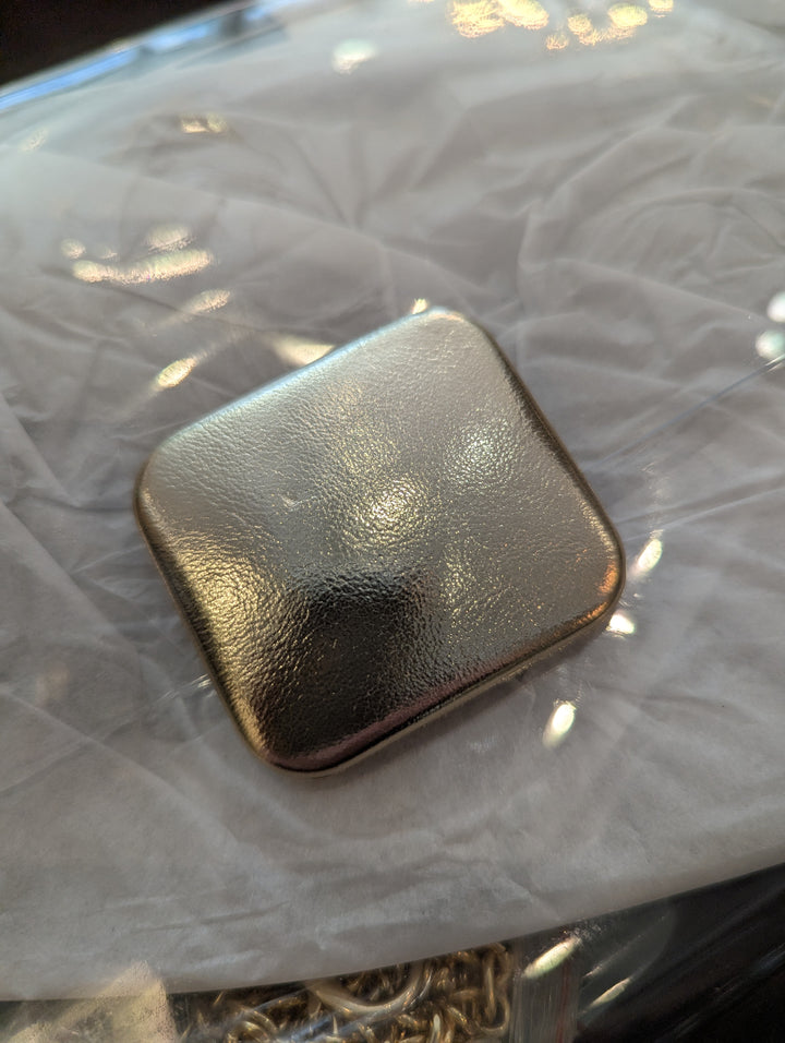 close up of the gold fastener on the stadium clutch