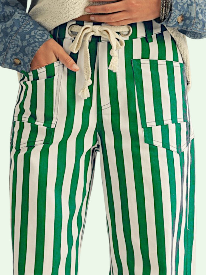 Green and white striped pants are shown on a model. she has her hand in the pocket.
