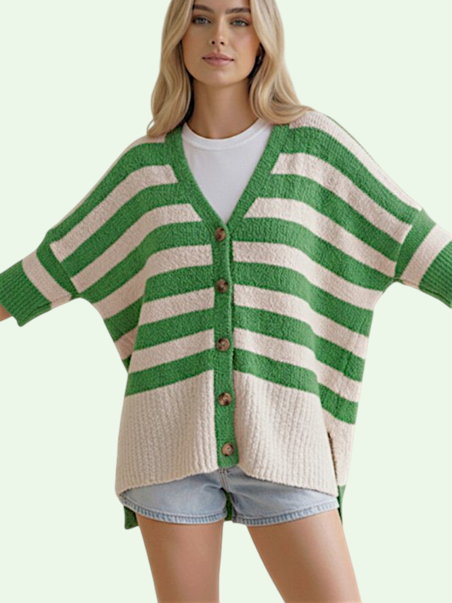 Woman wearing a green and white striped cardigan on a light green background