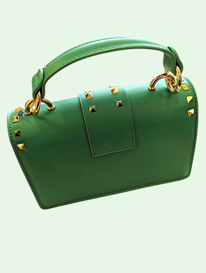 Green handbag with gold accents on a light green background