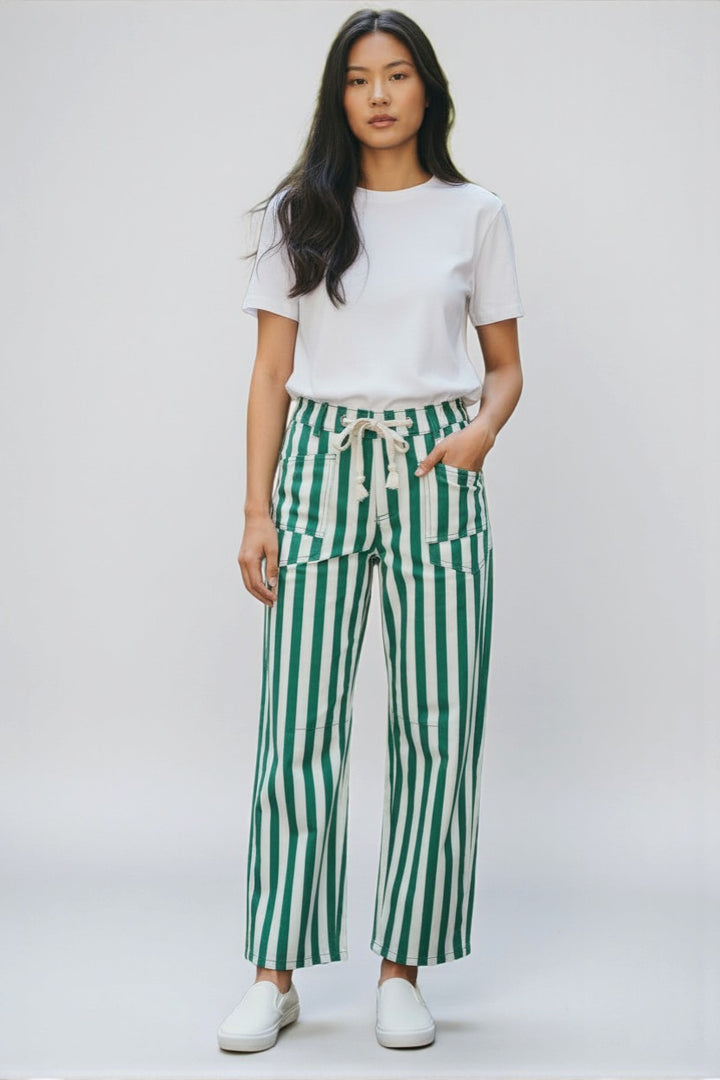 Person wearing a white t-shirt and green striped pants on a white background