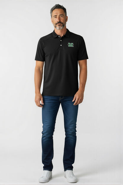 Man wearing a black polo shirt with a logo and blue jeans on a white background