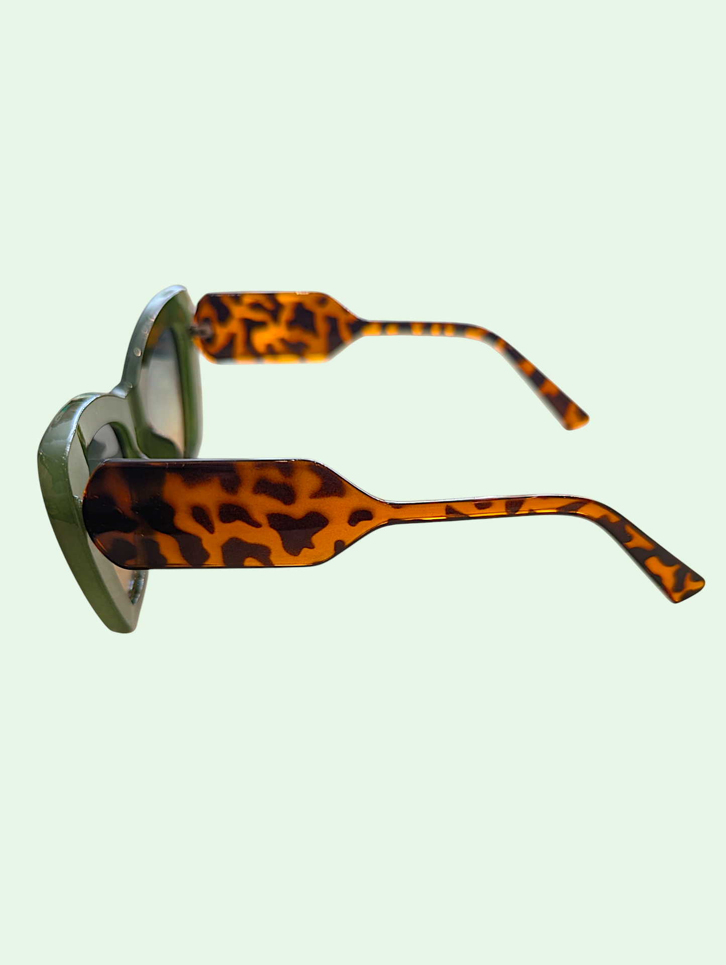 Sunglasses with leopard print arms on a light green background