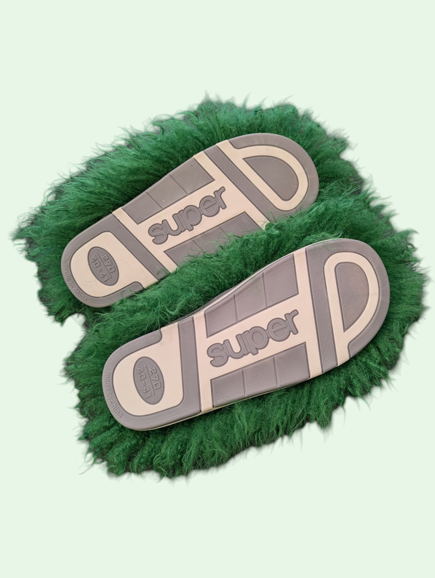 Green fuzzy sandals with 'super' branding on a light green background