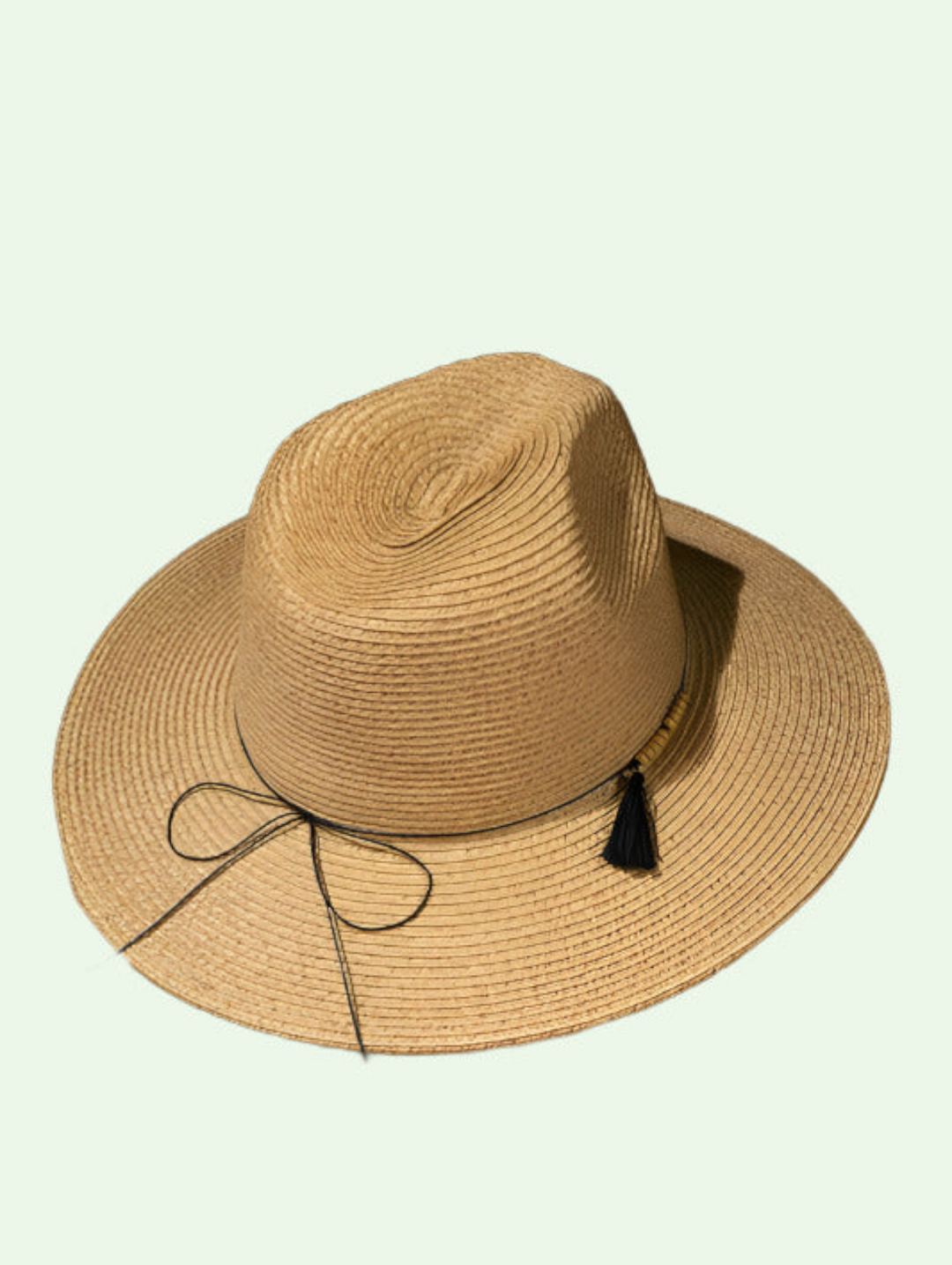 a natural color panama hat with a string and tassle decorating it