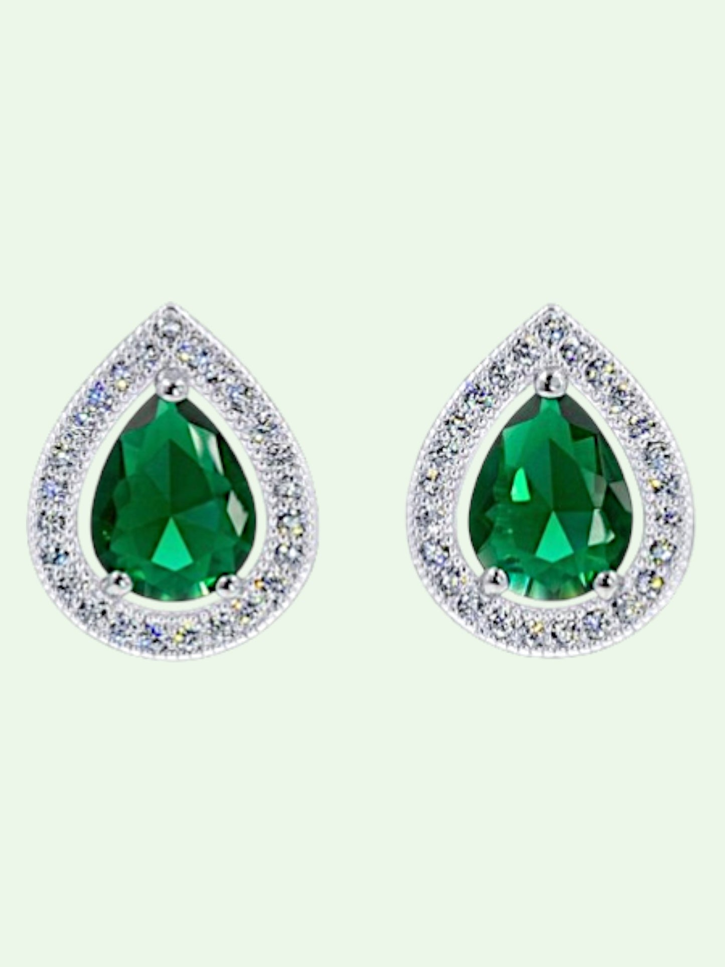 Teardrop-shaped green gemstone earrings with clear bezels on a light gray background