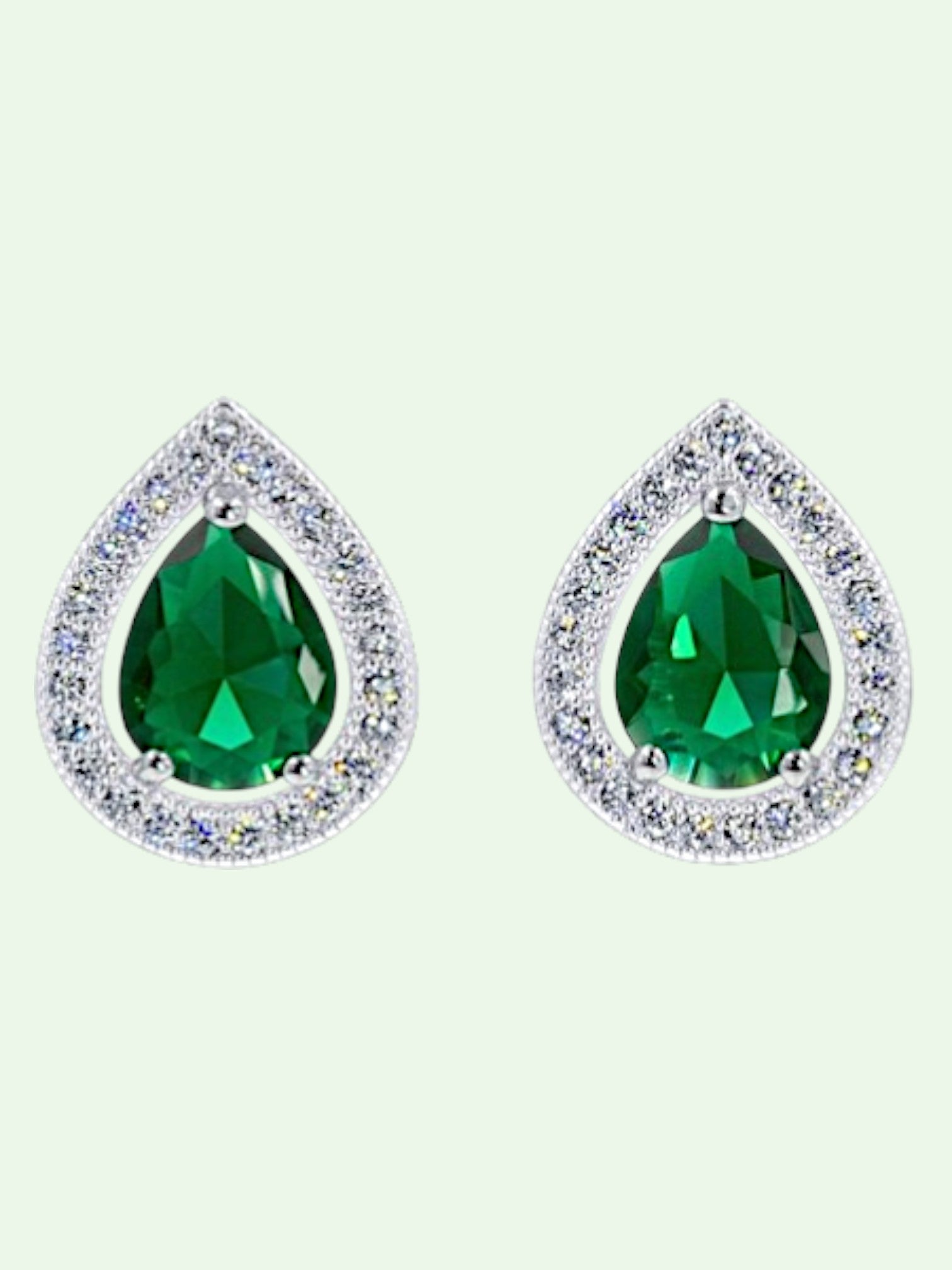 Teardrop-shaped green gemstone earrings with clear bezels on a light gray background