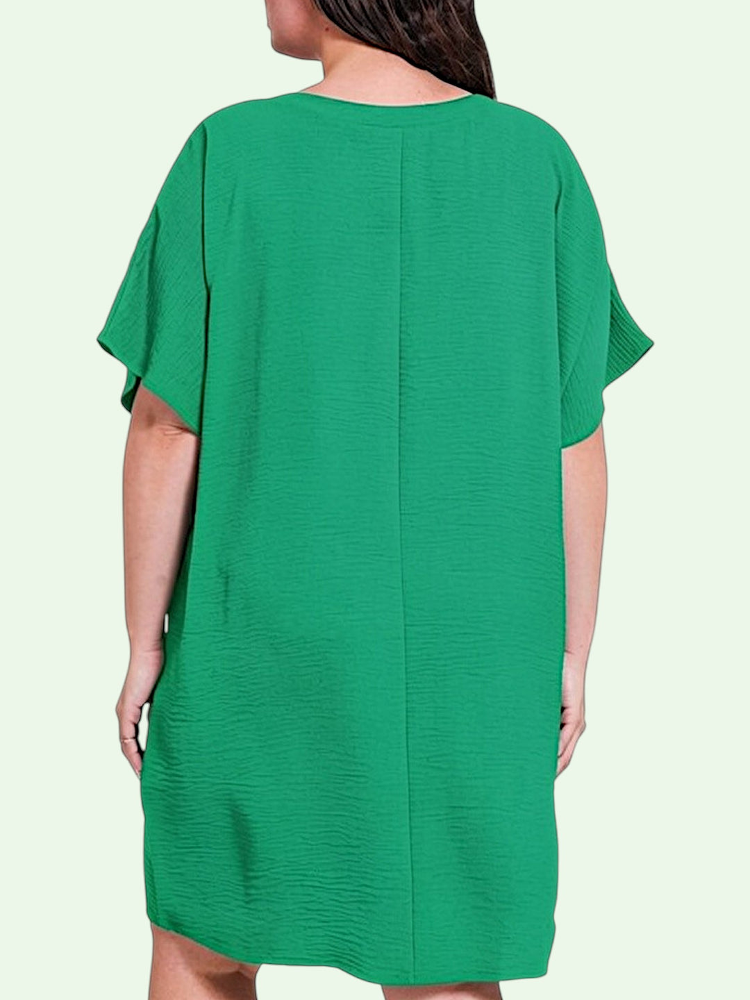 Green dress worn by a person on a light green background