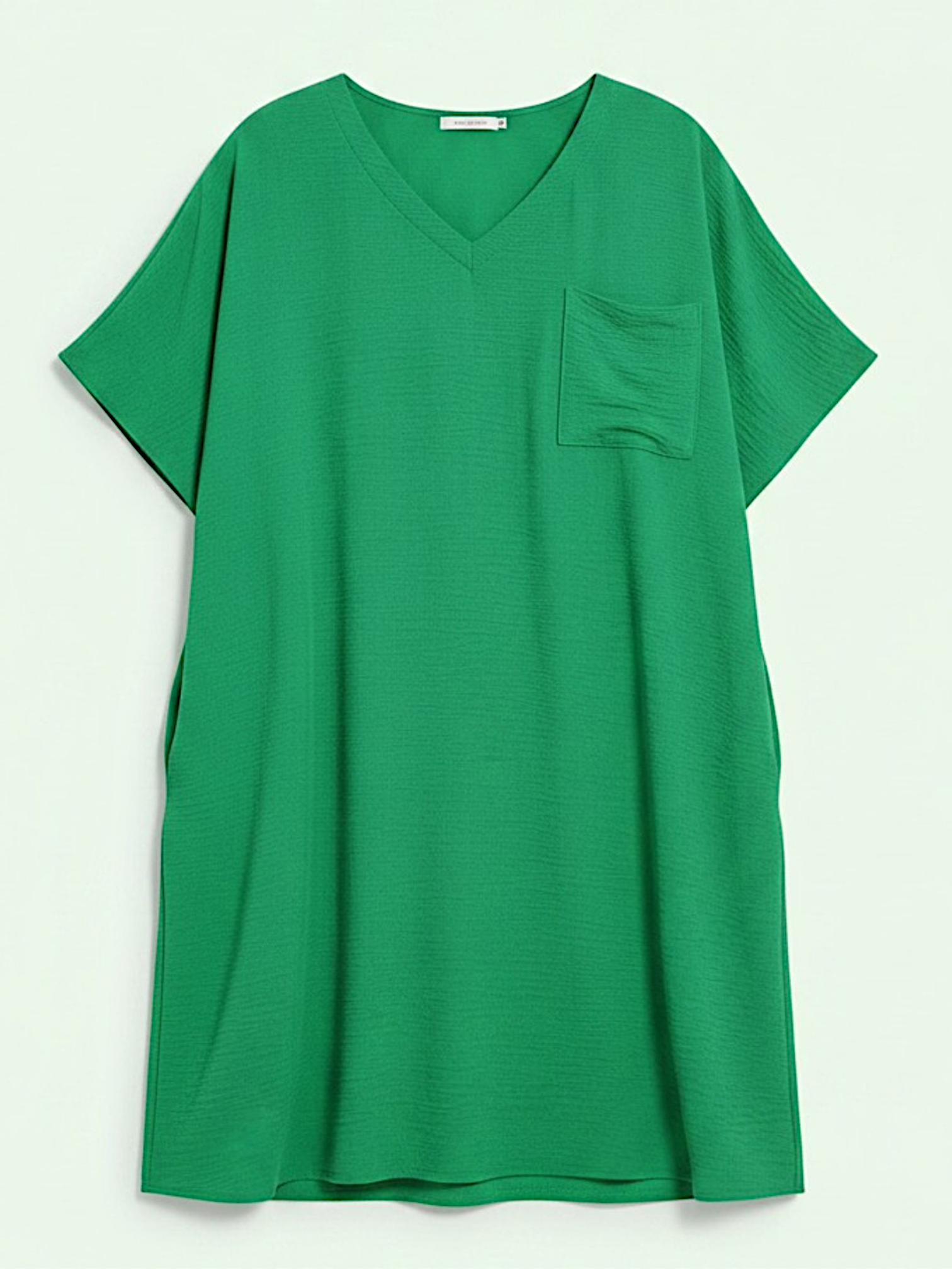 Green tunic with a pocket on a light gray background