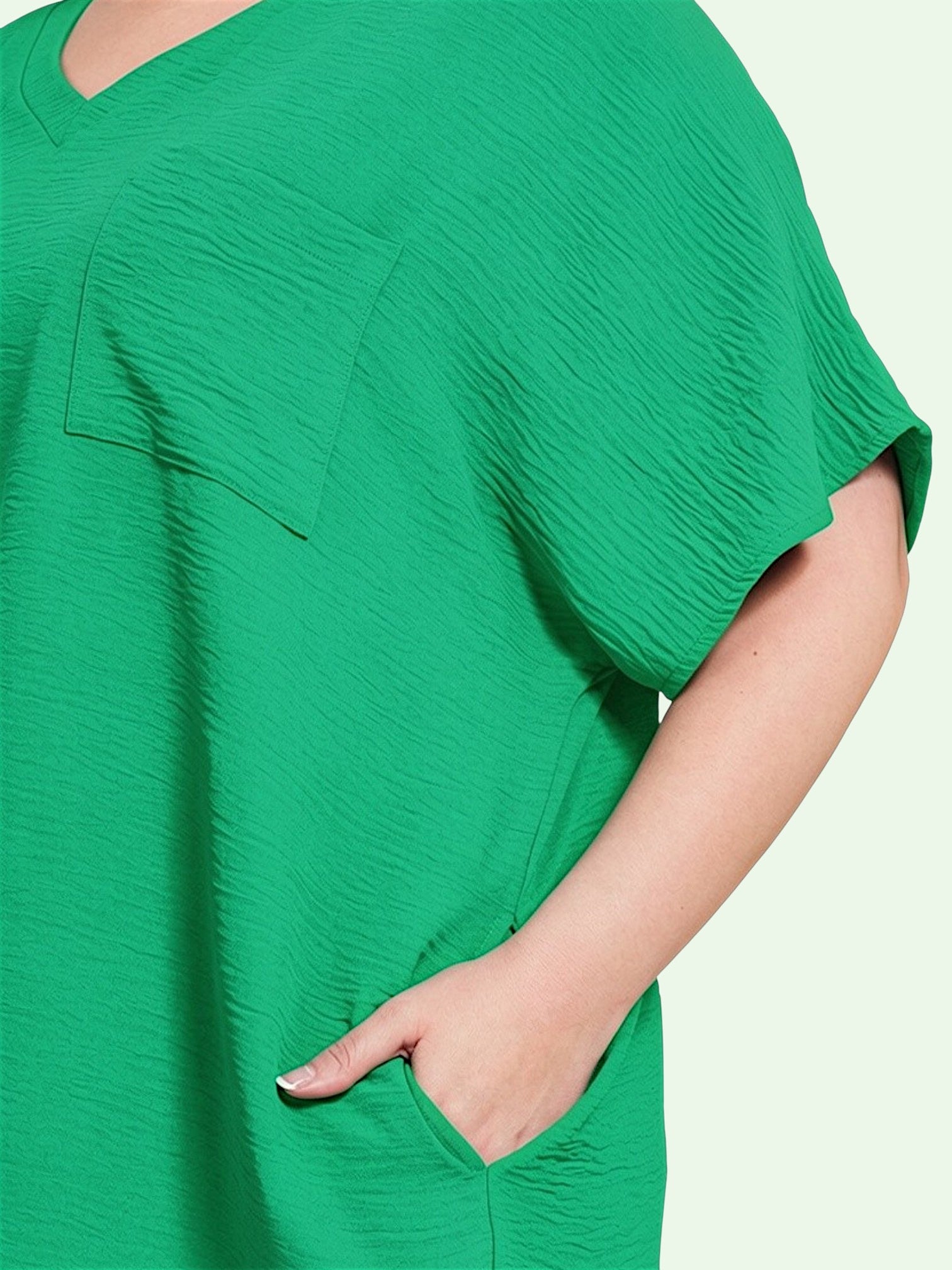 Green oversized t-shirt worn by a person on a light gray background