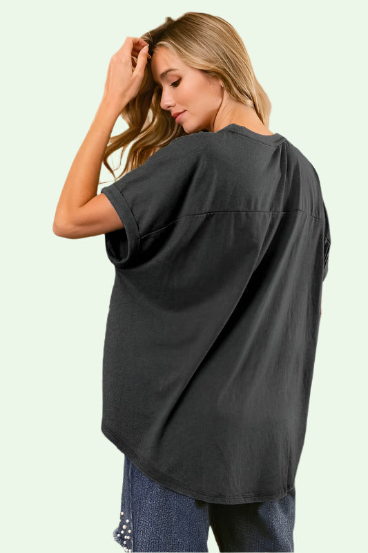 Woman wearing a dark gray oversized shirt in an elegant interior setting