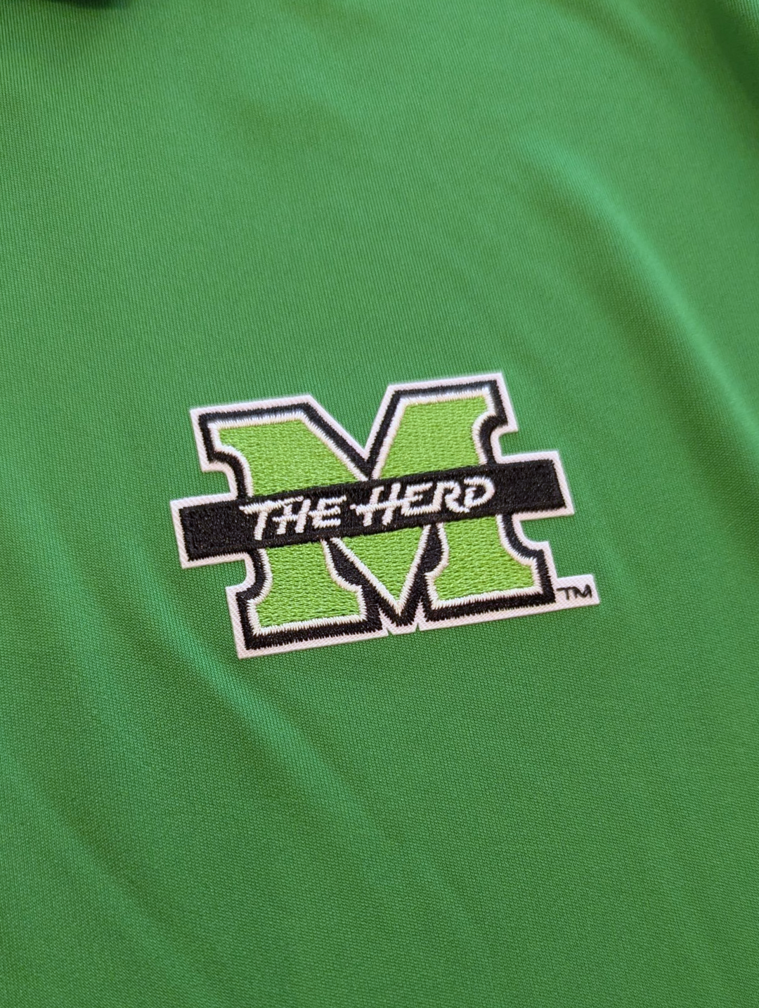 Green shirt with 'The Herd' logo on a green background