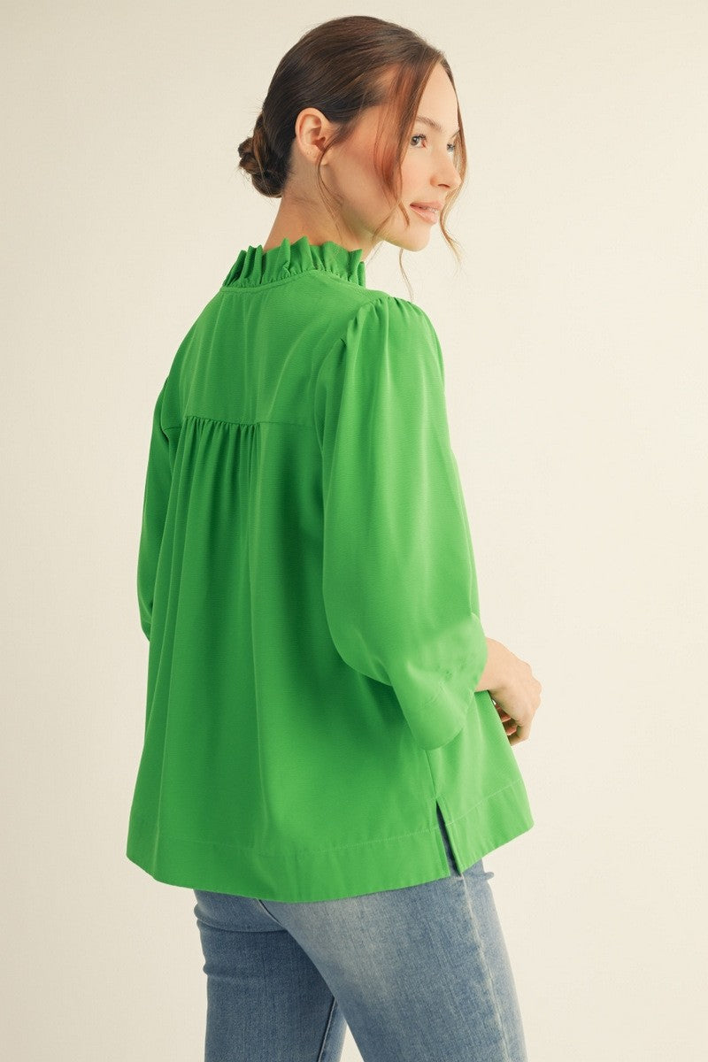 Woman wearing a green blouse with a plain background