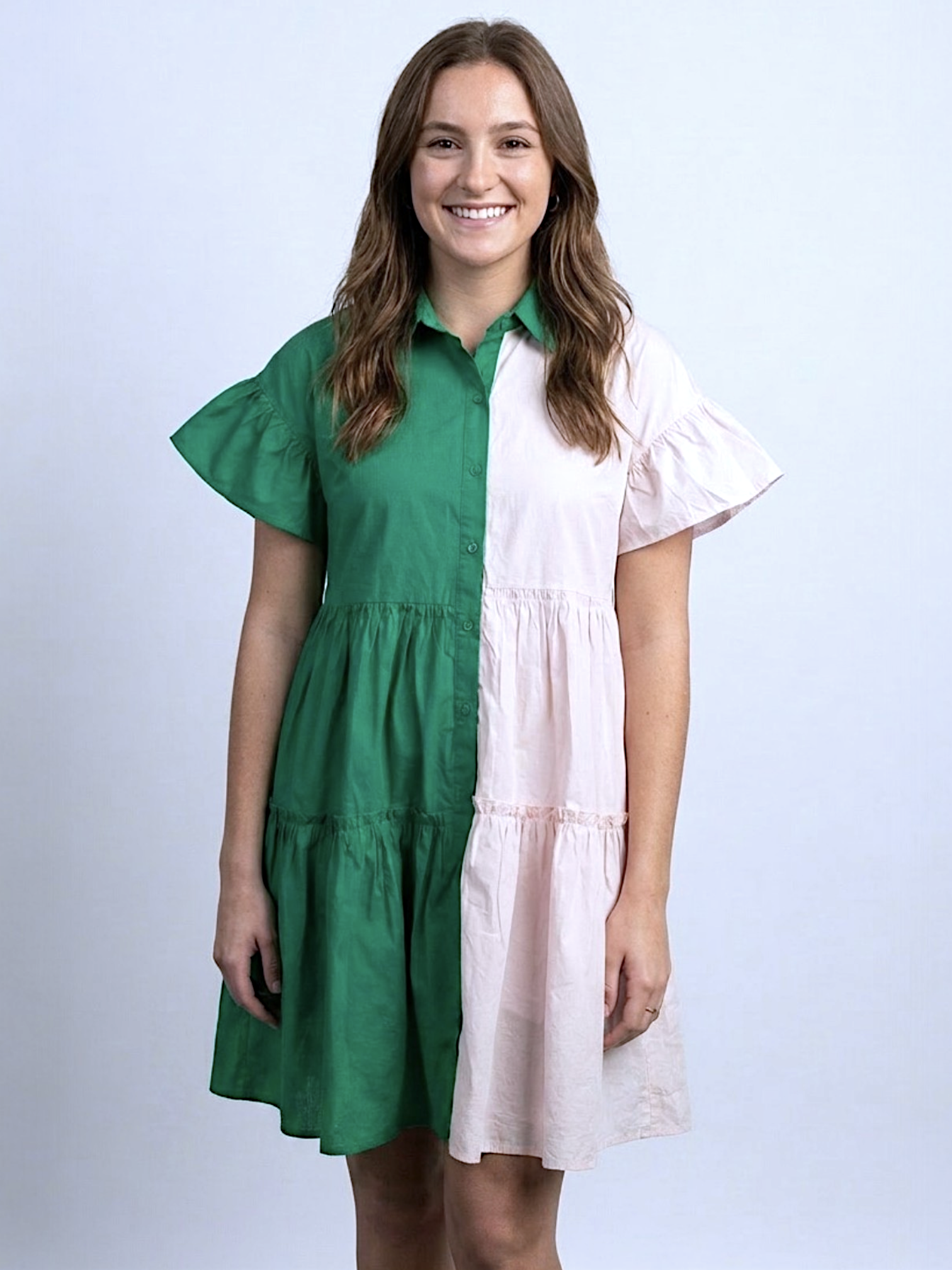 Woman wearing a green and white dress on a plain background