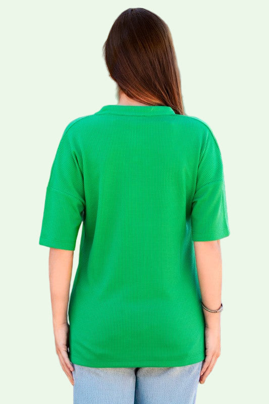 Person wearing a green shirt with a blurred background