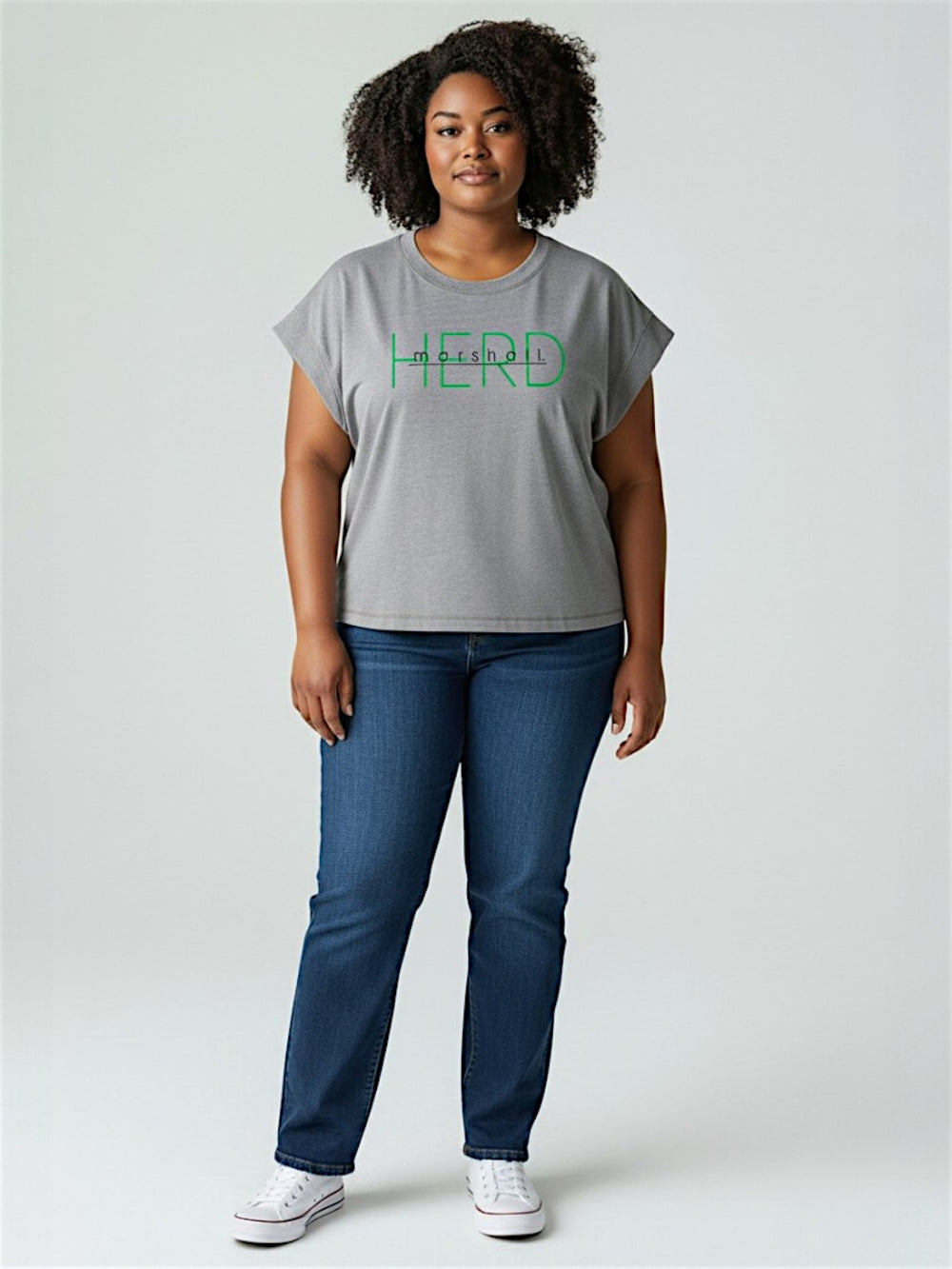 Person wearing a gray t-shirt with 'HERD' printed on it and blue jeans against a white background