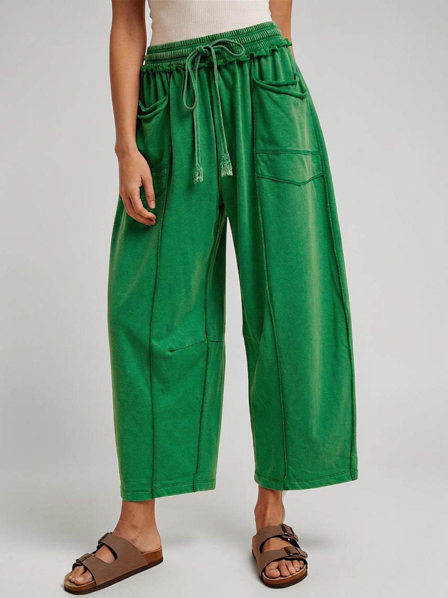 Green wide-leg pants worn by a person on a plain background