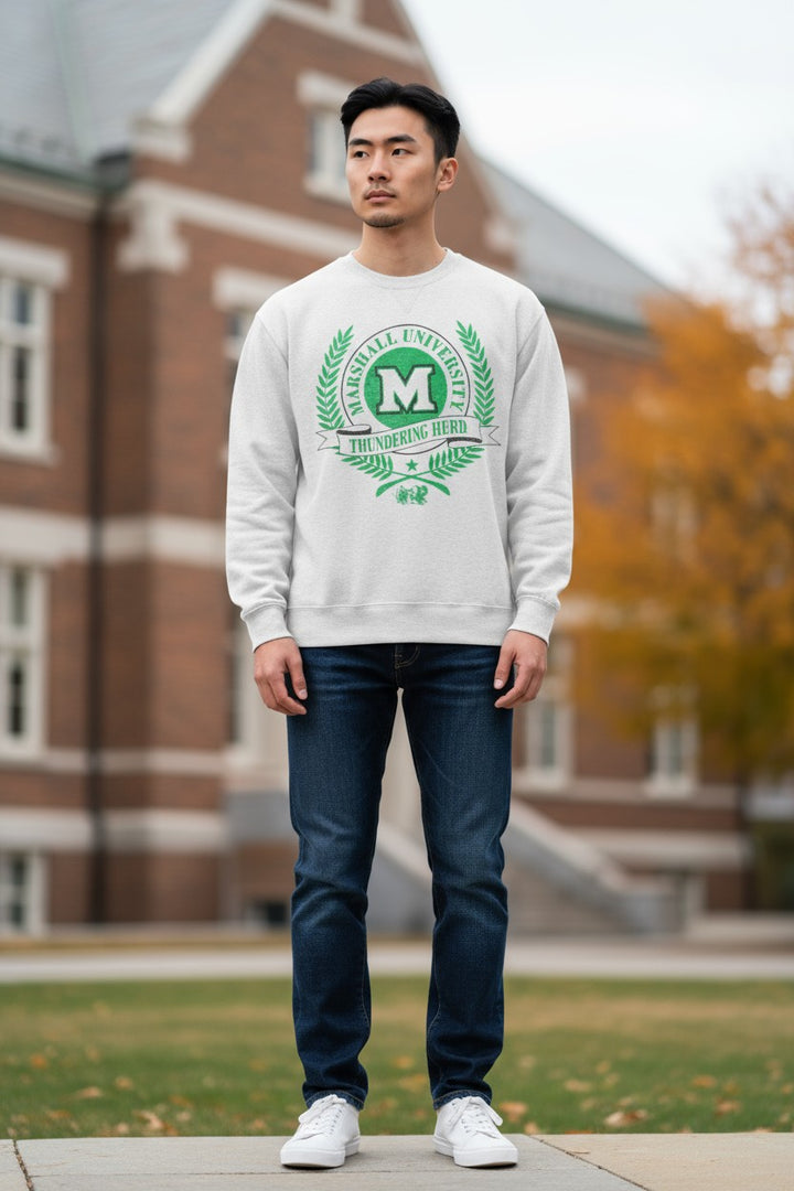 Man wearing a white sweatshirt with a green logo in front of a brick building