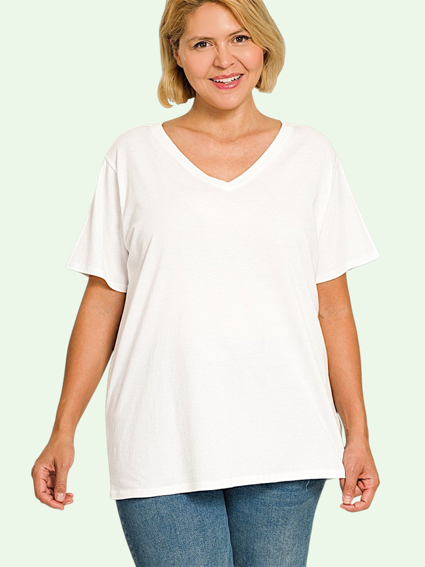 Woman wearing a white t-shirt and blue jeans on a light green background