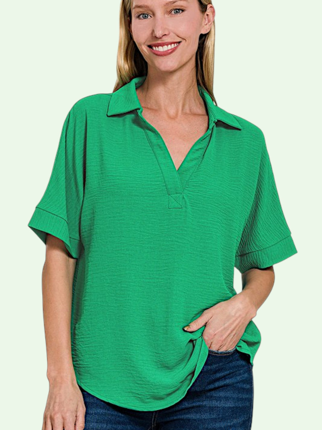 Woman wearing a green v-neck shirt on a light green background