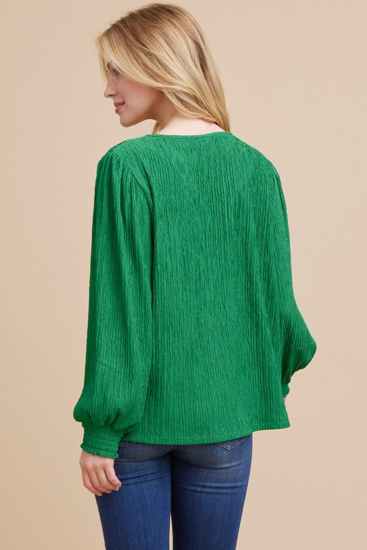 a blond model stands, her back to the camera, and shows us the reverse of the textured top. it is unremarkable. 