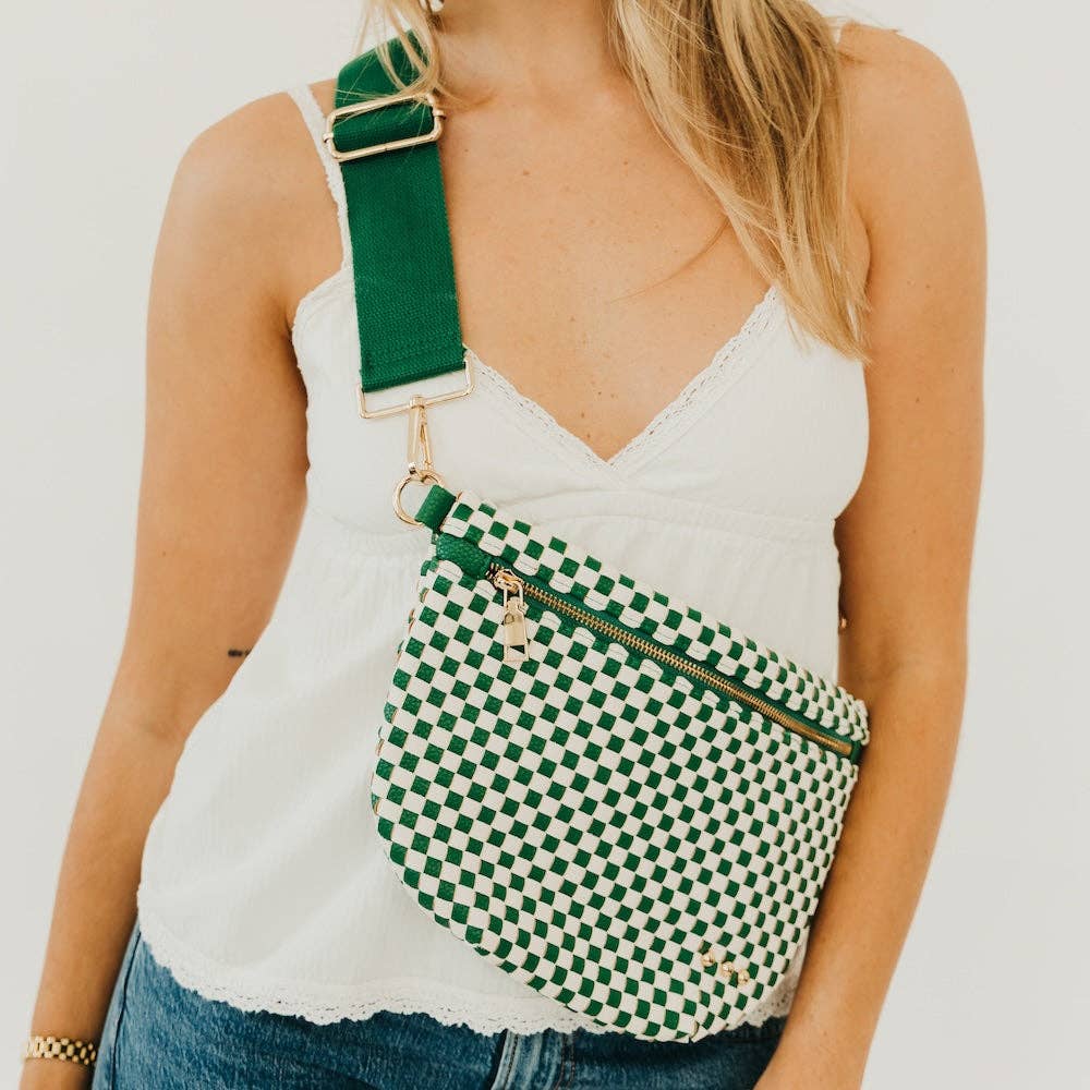 Person wearing a green and white checkered bag over one shoulder against a plain background