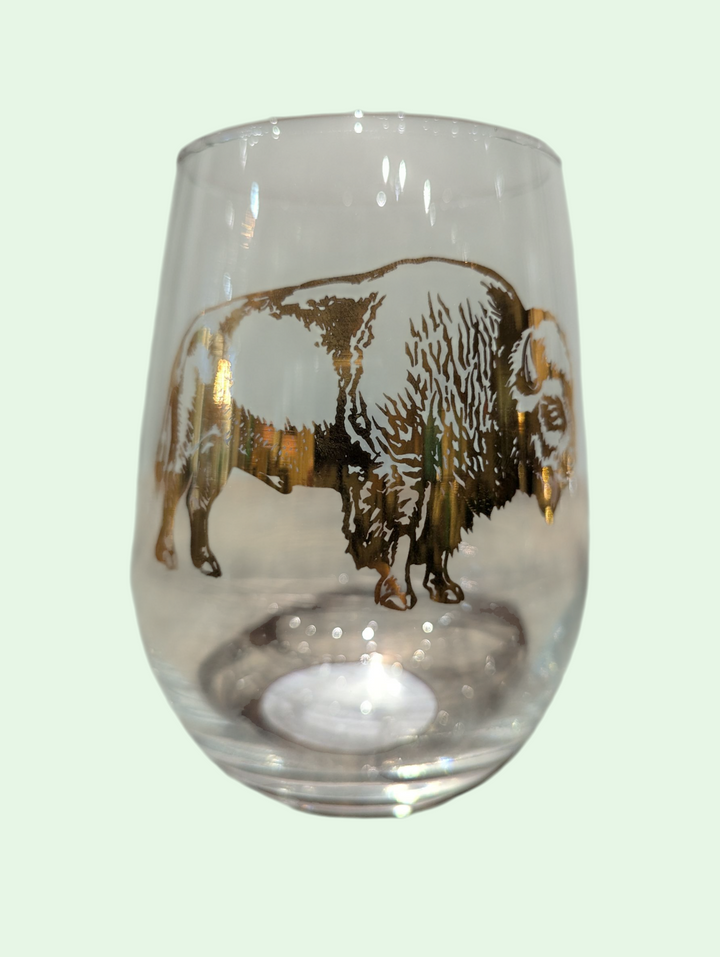 Clear glass with a gold bison design on a light green background