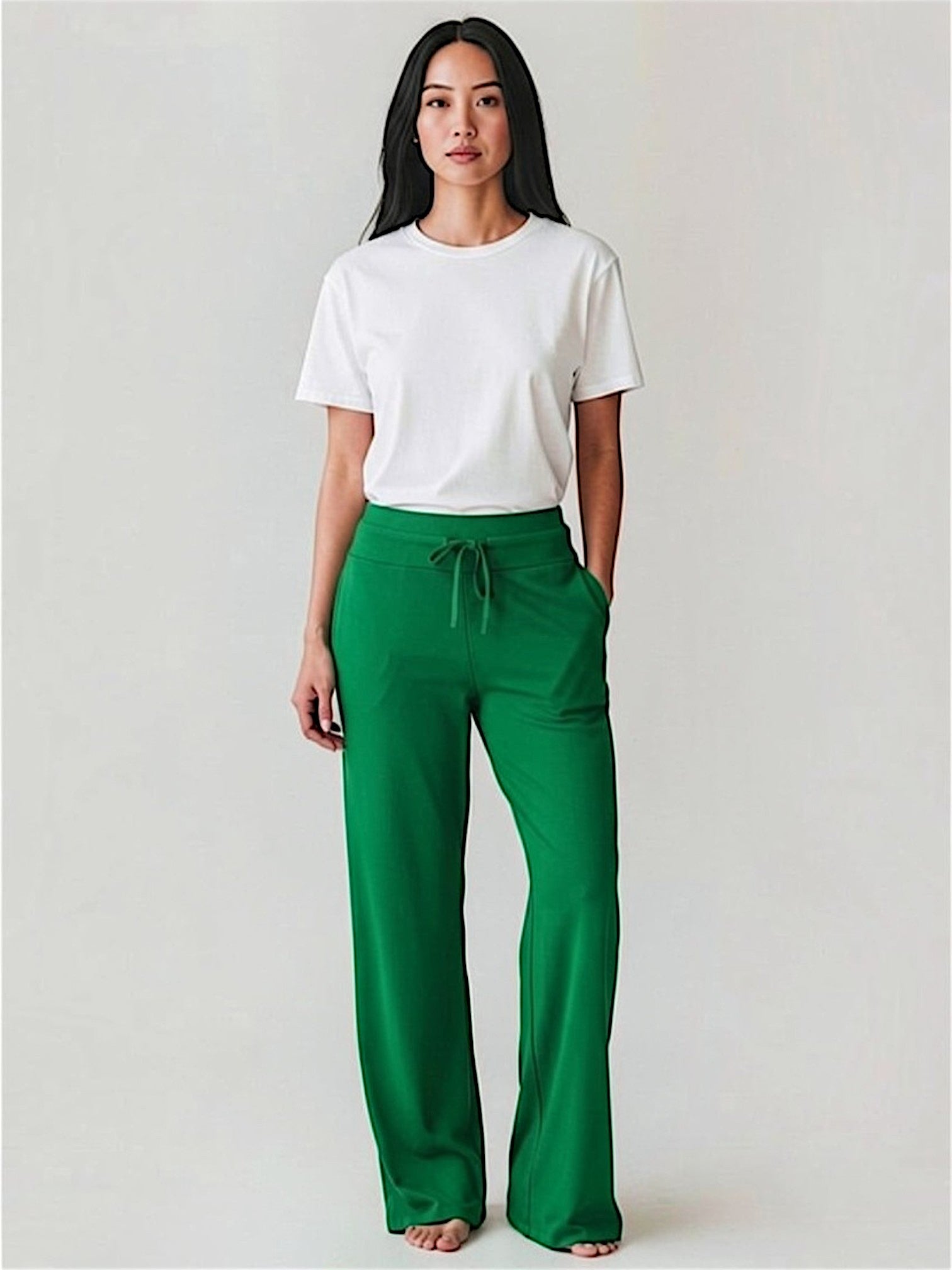 Person wearing a white t-shirt and green pants on a plain background