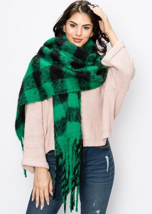 a dark haired model stands with her hand on her head and the scarf wrapped around her neck